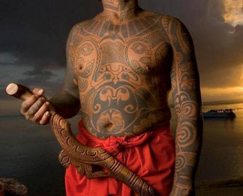 20 Jul 2005, Moorea, French Polynesia --- Roonui, famous Polynesian tattoo artist, stands near his studio in Hauru Point showing off his tattoos. --- Image by © Bob Krist/Corbis