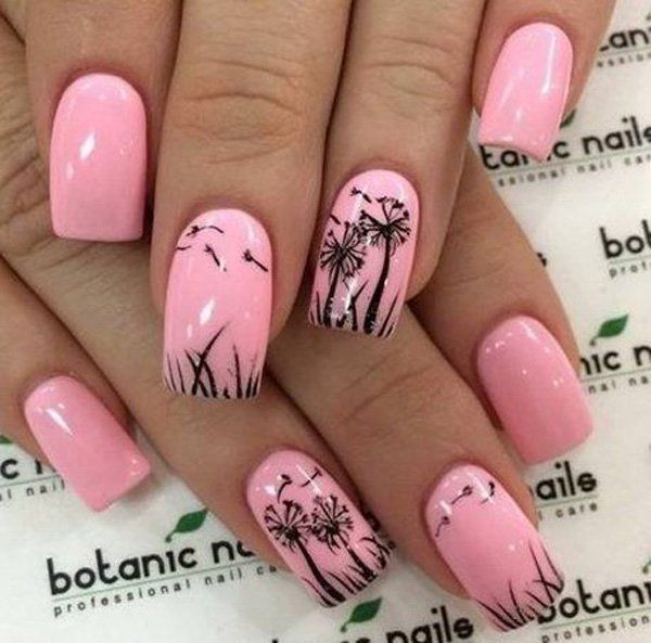 Elbűvölő nail art with dandelions outlined on the baby pink nails.