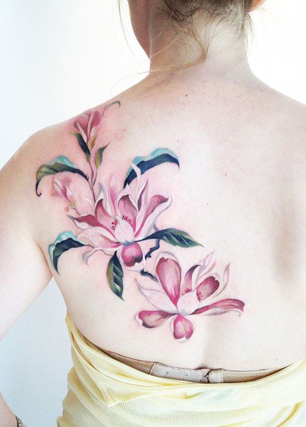 Pink magnolia flower tattoo on the back - a feminine tattoo idea for women