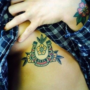 59 Lucky horseshoe underboob sternum American traditional tattoo by Tony Talbert