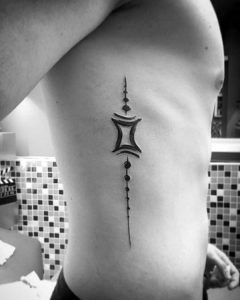 abstract-gemini-male-rib-cage-side-tattoo-with-black-ink-design