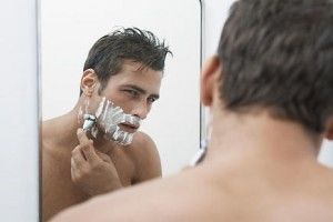 la mijlocul adult man shaving beard