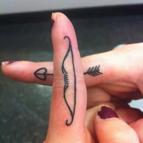 Bow with arrow love tattoo on finger