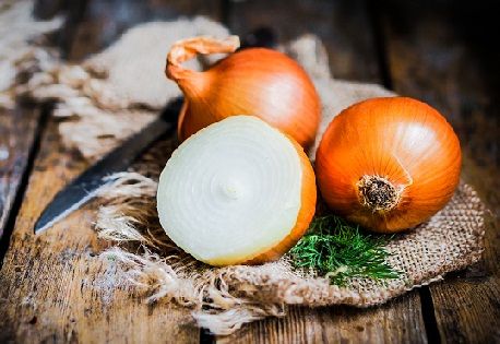 Auksinis onions on rustic wooden background