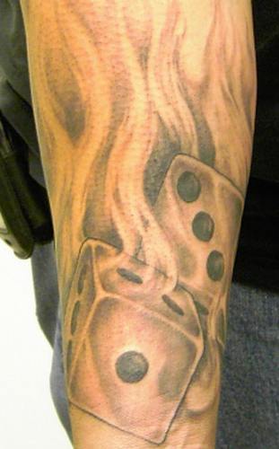 A Skull And Dice Fire Tattoos on Forearm
